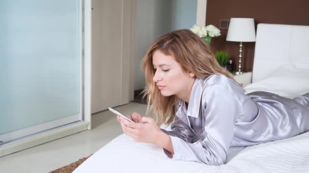 Mujer joven utiliza un teléfono inteligente, comunicarse en los mensajeros instantáneos y utilizar la aplicación móvil — Vídeos de Stock