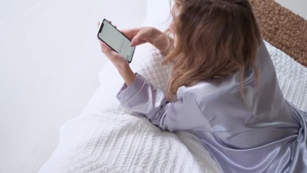Νεαρή γυναίκα χρησιμοποιεί ένα smartphone, επικοινωνώντας με τους άμεσους αγγελιοφόρους και να χρησιμοποιήσετε την εφαρμογή για κινητά — Αρχείο Βίντεο