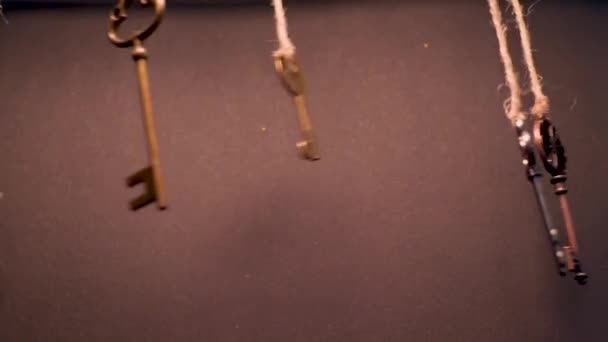 A lot of different old keys from different locks, hanging from the top on strings. — Stock Video