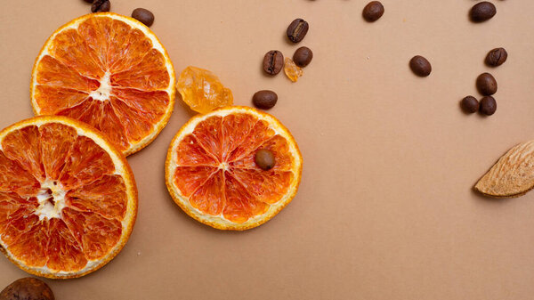 Citrus and spicy background with coffee beans and spices, warm ochre background