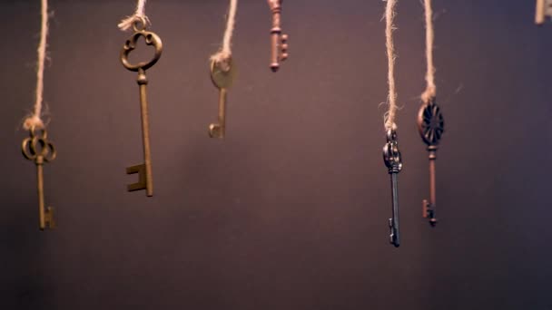 Un sacco di vecchie chiavi diverse da serrature diverse, appese dalla cima su stringhe. — Video Stock