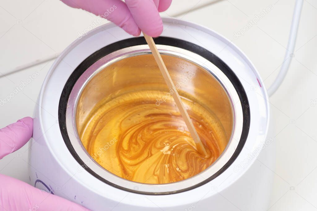 Wax for hair removal. Molten wax in a special container for heating the wax.