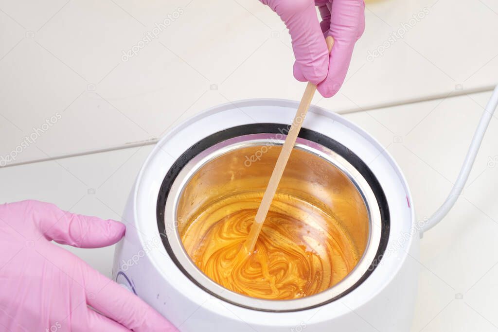 Wax for hair removal. Molten wax in a special container for heating the wax.