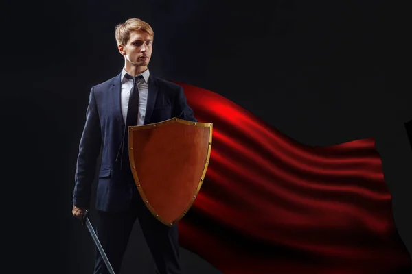 Super hero in a red cloak and with a shield and sword, the concept of an anti-crisis — Stock Photo, Image