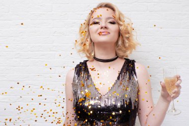 Mutlu ve neşeli sarışın, bir bardak şampanyayla, bayramı kutluyor..