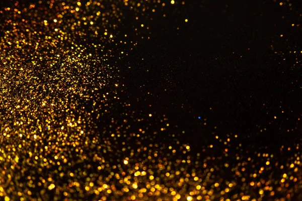 Funkelndes Gold glitzert auf schwarzem Hintergrund, magischer abstrakter Hintergrund. Rundrahmen aus Goldpartikeln, — Stockfoto