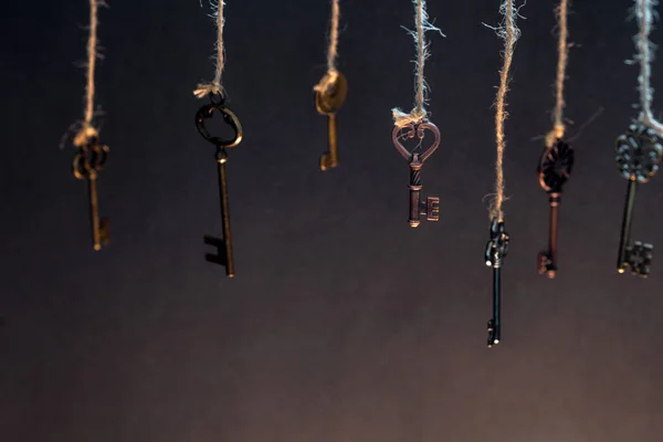 Viele verschiedene alte Schlüssel aus verschiedenen Schlössern, die von oben an Saiten hängen. — Stockfoto