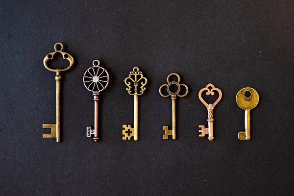 Muchas llaves viejas diferentes de diversas cerraduras, en orden en una línea, puesta plana. — Foto de Stock
