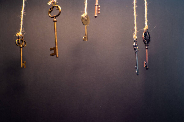 A lot of different old keys from different locks, hanging from the top on strings.