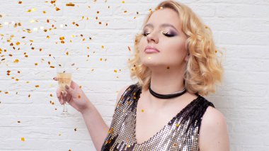 Mutlu ve neşeli sarışın, bir bardak şampanyayla, bayramı kutluyor..