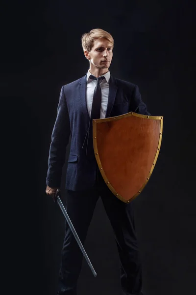 Manager with shield and sword protects business, the concept of crisis management — Stock Photo, Image