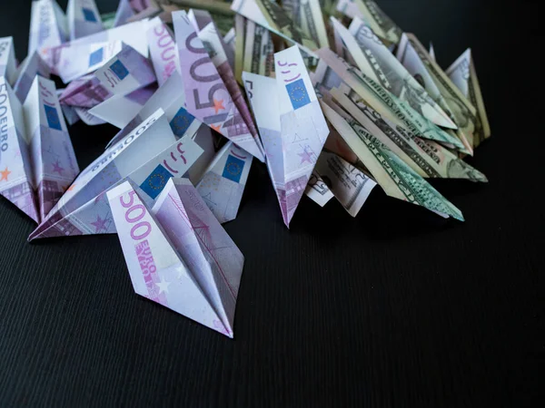 Cash flow, concept. A large pile of paper planes made from cash, dollars and euros.