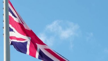 Büyük Britanya bayrağı rüzgarda dalgalanıyor. Mavi gökyüzüne karşı ulusal bayrak,
