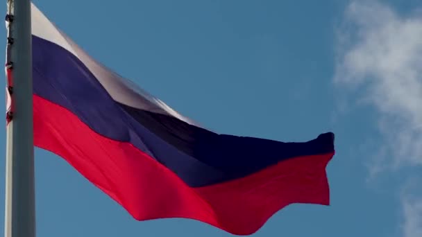 Bandeira russa a tremer ao vento. Bandeira nacional contra um céu azul, — Vídeo de Stock