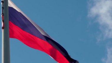 Rüzgarda dalgalanan Rus bayrağı. Mavi gökyüzüne karşı ulusal bayrak,