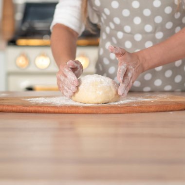 Diz hamuru, el hamuru ve un yakın plan. Gri benekli önlüklü bir pasta şefi..