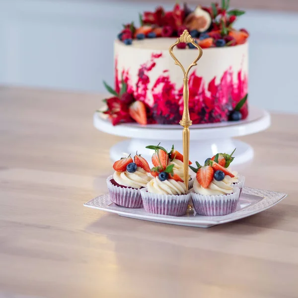 그 위에 꽃과 열매가 달린 크고 아름다운 붉은 벨벳케이크. 크림을 곁들인 달콤 한 머핀, — 스톡 사진
