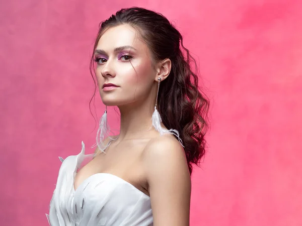Porträt einer jungen schönen Frau in elegantem weißem, strukturiertem rosa Hintergrund. — Stockfoto