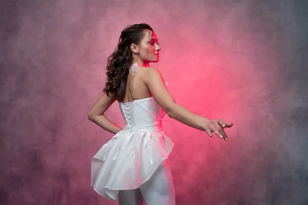 Portrait of a young beautiful woman in a smart white pantsuit, textured pink background. — Stock Photo, Image