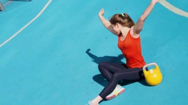 Genç bayan sporcu antrenman yapıyor, açık havada bir su ısıtıcısıyla antrenman yapıyor..