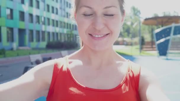 젊은 여자 운동 선수가 옥외에서 물총새를 가지고 훈련하면서 운동을 하고 있다. — 비디오