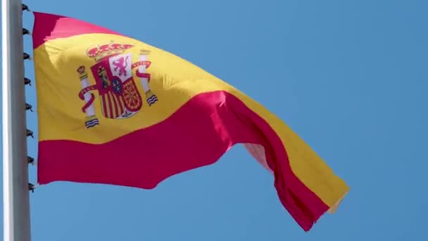 Hiszpańska flaga wisząca na wietrze. Flaga narodowa przeciwko błękitnemu niebu, — Wideo stockowe