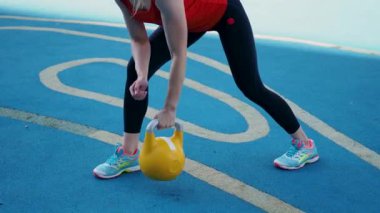 Genç bayan sporcu antrenman yapıyor, açık havada bir su ısıtıcısıyla antrenman yapıyor..