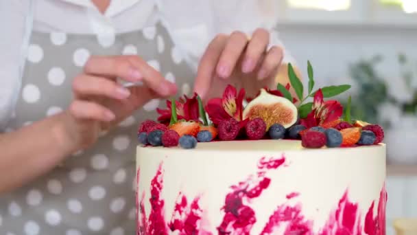 Cottura e decorazione di torta con crema. Giovane pasticcere donna in cucina decorazione torta di velluto rosso — Video Stock