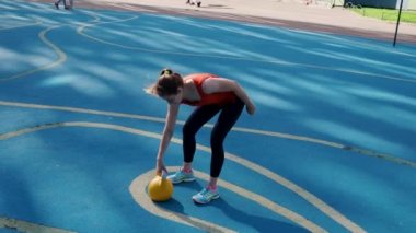 Genç bayan sporcu antrenman yapıyor, açık havada bir su ısıtıcısıyla antrenman yapıyor..