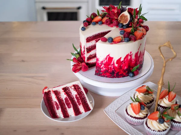 그 위에 꽃과 열매가 달린 크고 아름다운 붉은 벨벳케이크. 접시 위에서 슬라이스, 디저트. — 스톡 사진