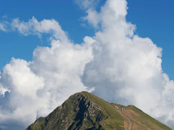Pico da montanha e uma nuvem branca exuberante acima dela. — Fotografia de Stock