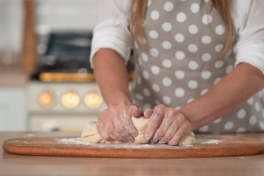 Diz hamuru, el hamuru ve un yakın plan. Gri benekli önlüklü bir pasta şefi..