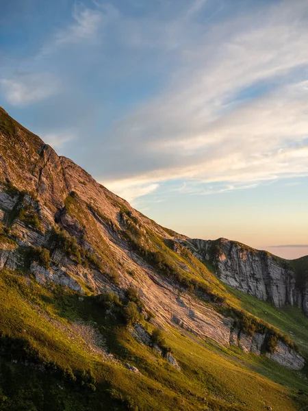 Pôr do sol nas montanhas. Declive de montanha com rochas e grama, — Fotografia de Stock