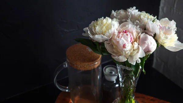 De belles pivoines blanches luxuriantes dans un vase sur fond noir, — Photo