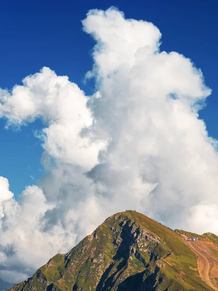 Pico de la montaña y una exuberante nube blanca sobre ella. —  Fotos de Stock