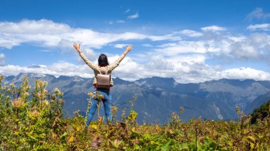 Dünyayı kucakla. Dağlarda seyahat eden mutlu genç kadın..