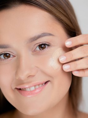 Vakfı ellerinle uygula. Genç ve güzel bir kadın kendi makyajını yapıyor, pürüzsüz ten rengi.,