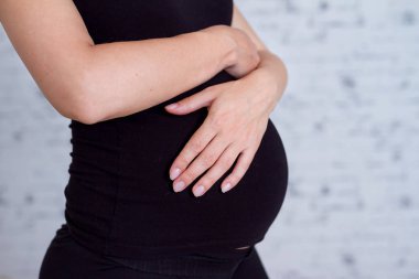 Hamile kadın karnını tutuyor.