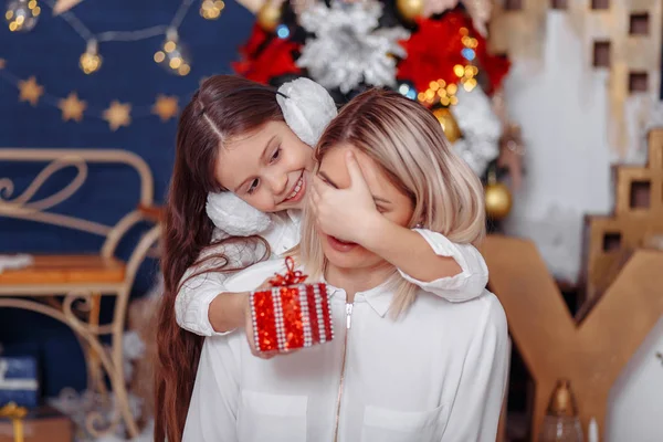 Daughter gives gift to mother.