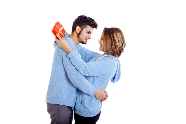 Man giving a gift to a woman, holding her. — Stock Photo, Image