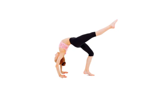 Flexible niña gimnasta haciendo un puente sobre fondo blanco . — Foto de Stock