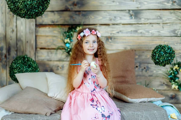 Happy child girl paints eggs for Easter. — Stock Photo, Image