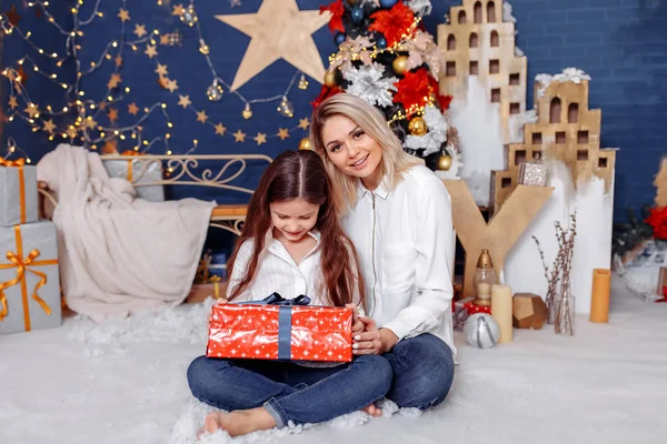 Beautiful young mother with her daughter in the New Year`s inter — Stock Photo, Image