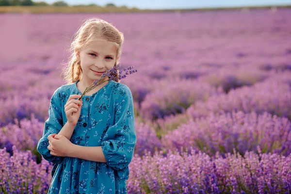 ラベンダー畑にラベンダーの花束を持つ美しい女の子 — ストック写真