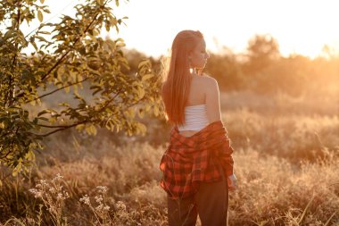 Batan güneşin ılık ışınlarında güzel bir kadın.