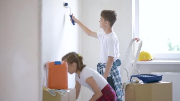 Діти малюють стіну в кімнаті — стокове відео