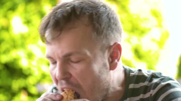Чоловік їсть фастфуд — стокове відео