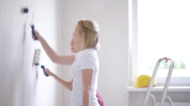 Мати і дочка розмальовують стіну — стокове відео