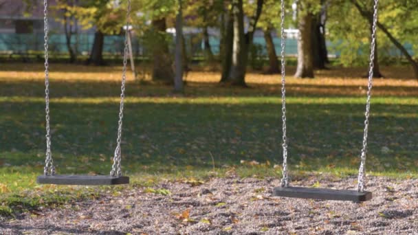 Columpios vacíos en el parque infantil — Vídeo de stock