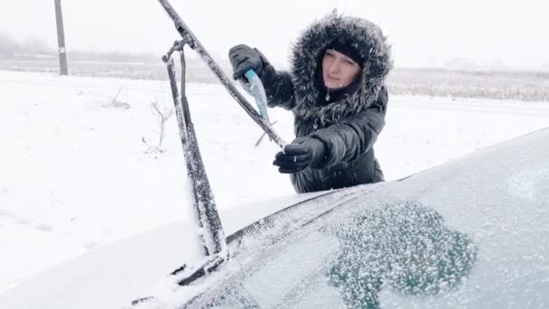 Kvinna rengöring bil från snö — Stockvideo